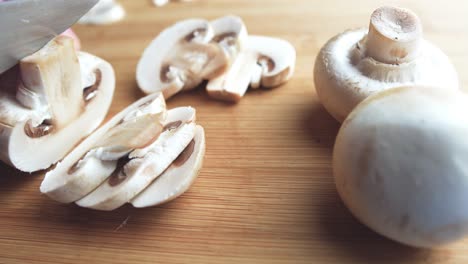 Chopping-mushroom-on-a-wooden-cutting-board