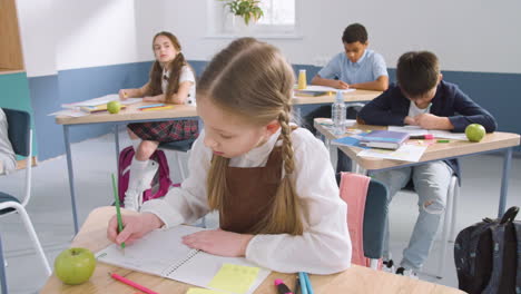 Pensive-Female-Student-Sitting-At-Desk-And-Thinking-About-Something-At-School