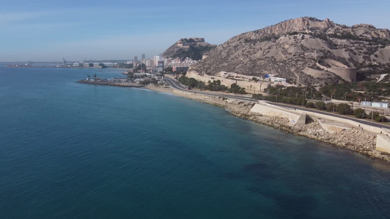 Aerial view of the coastal walk in the north of the city of Alicante. Sangueta mount and Santa Barbara castle in the background.