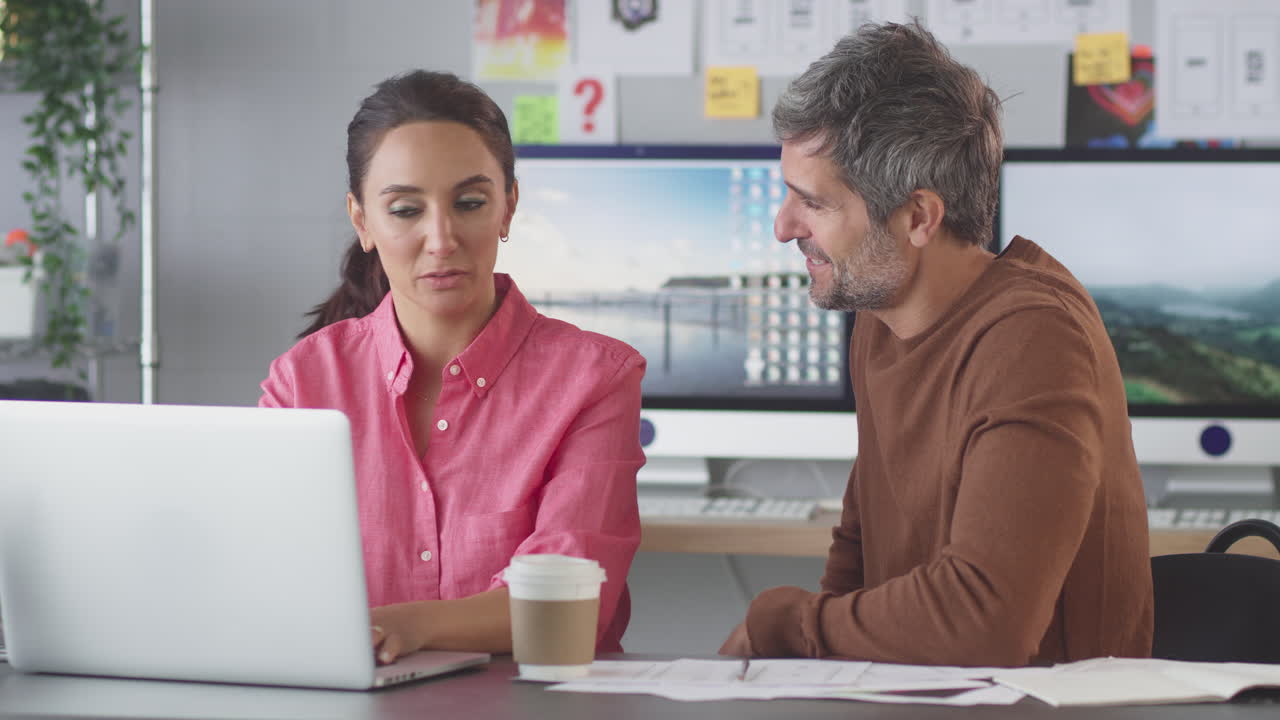 hombre de negocios y mujer de negocios en una oficina creativa trabajando juntos en un escritorio en una computadora portátil