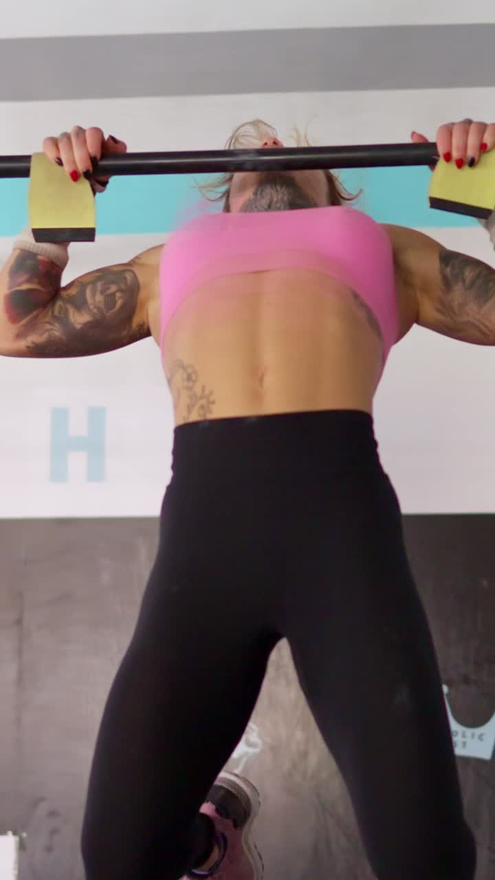 Mulher forte fazendo barra em uma academia