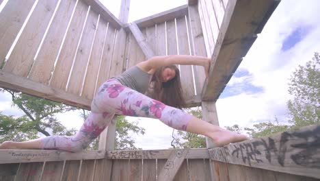 hermosa mujer haciendo las divisiones al aire libre en un día soleado