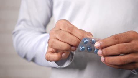 person opening a blister pack of pills