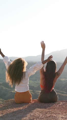 two women enjoying the sunset over a mountainous landscape
