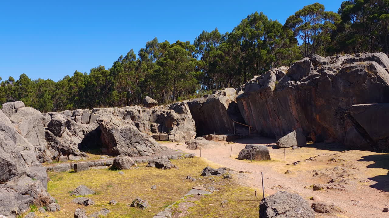 A wide-angle video showcasing the ancient Q'enqo archaeological site near Cusco, Peru. The large carved stones, labyrinthine passages, and sacred spaces of this mysterious Inca ritual site