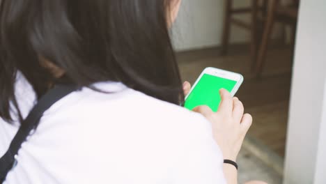 mujer usando un teléfono inteligente en un columpio