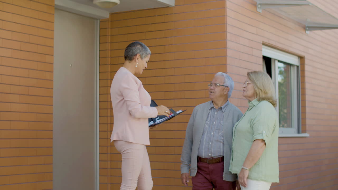 Caucasian senior couple talking with a real estate agent about buying a new property outdoors