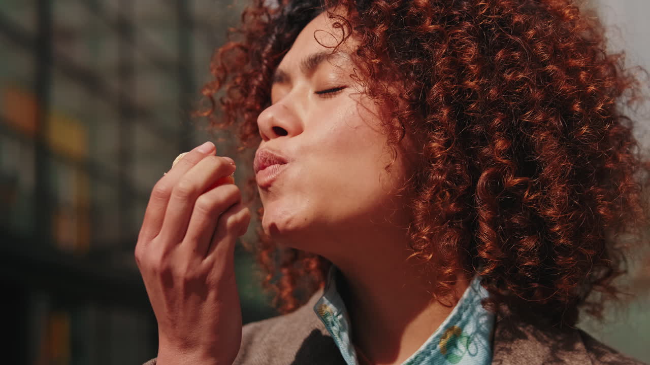 Young Woman Eating a Mandarin Orange Outdoors