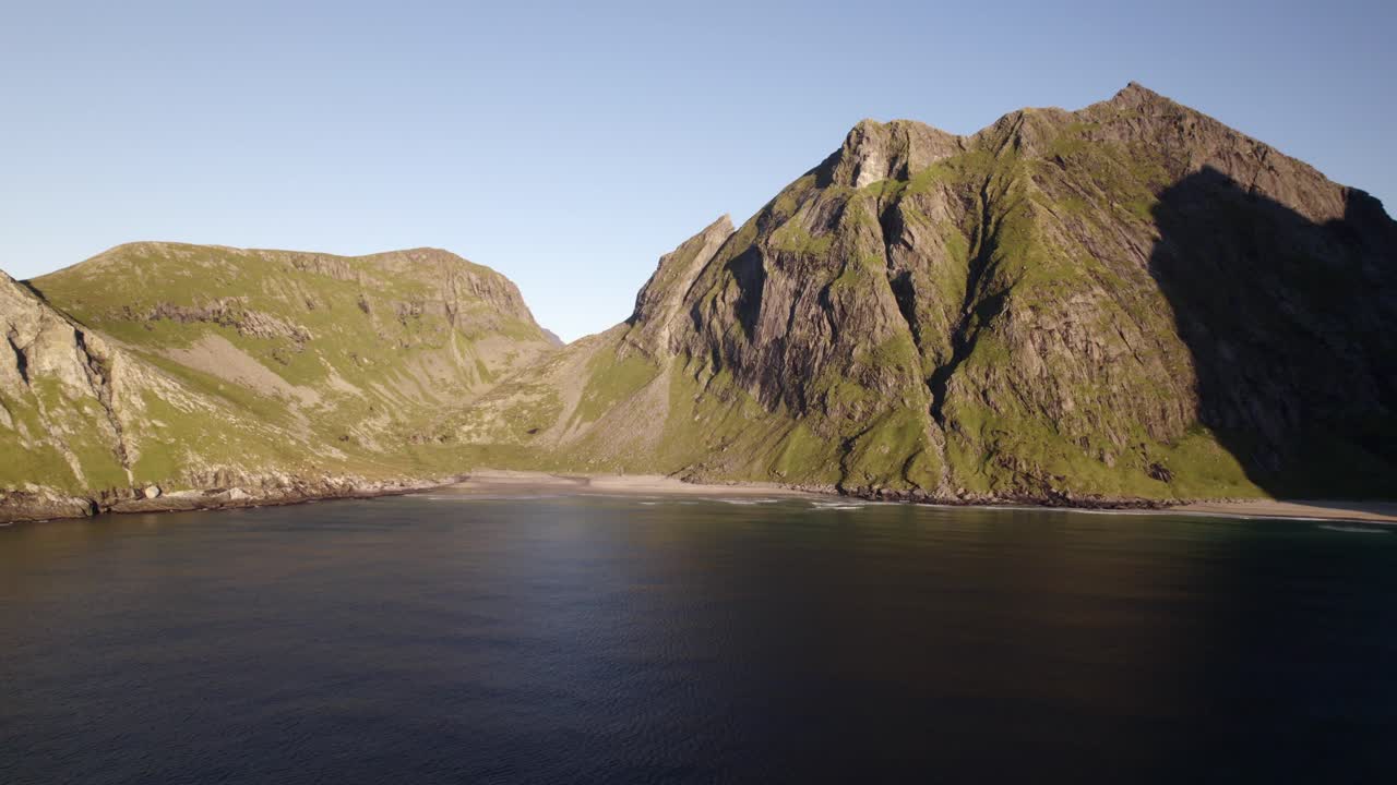 바다에서, 노르웨이 크발비카 해변에서 웅장한 녹색 산의 공중 촬영