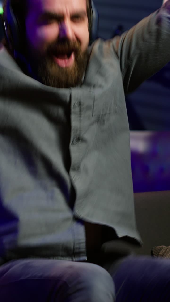 Vertical video Ecstatic man gaming at home yelling from joy after achieving victory