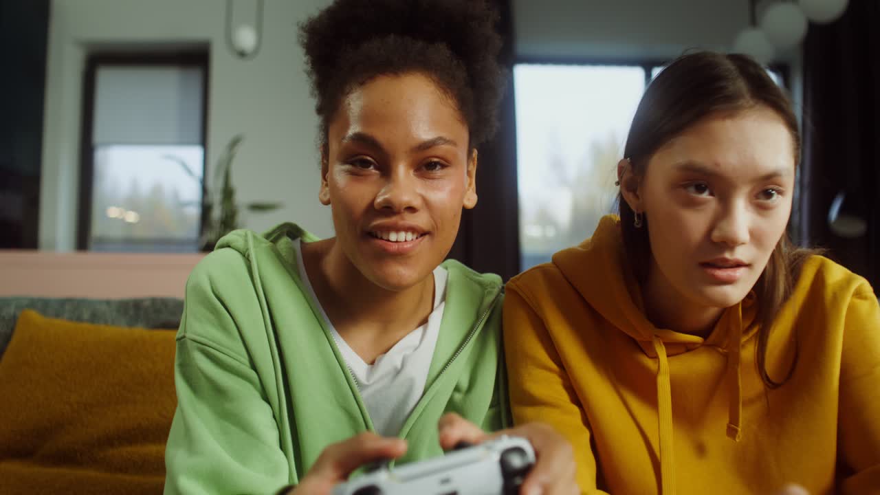 Two young women play video games