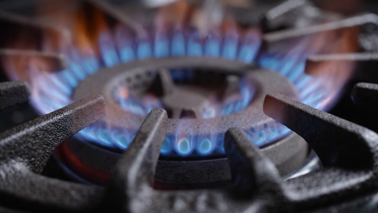 A Close-Up Exploration of a Gas Stove Ignition Process, Capturing the Transition from Sparks to a Steady Blue Flame for Cooking