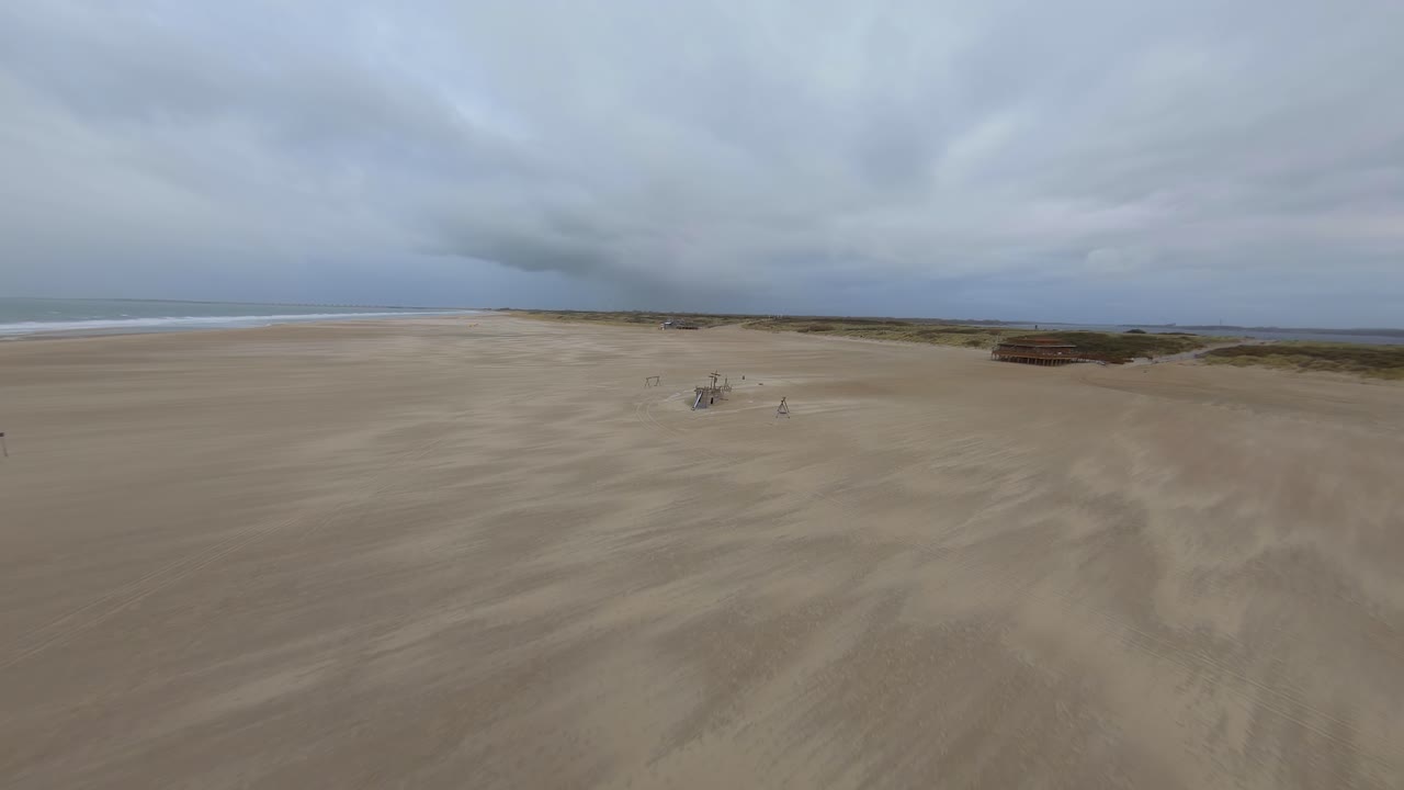 gaviota pasando un dron volando hacia un barco de madera en la playa