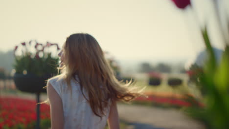 happy girl with flowing hair jumping in summer garden. beautiful woman laughing.