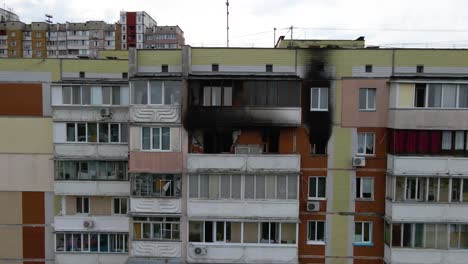 drone shot away from a old building, with burnt apartments, in a poor poverty area of kyiv, overcast day, in kiev, ukraine - pull back, aerial view