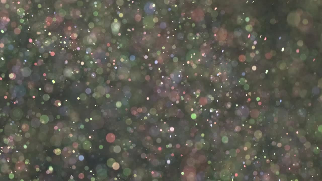 блестящие частицы, плавающие на темном фоне.