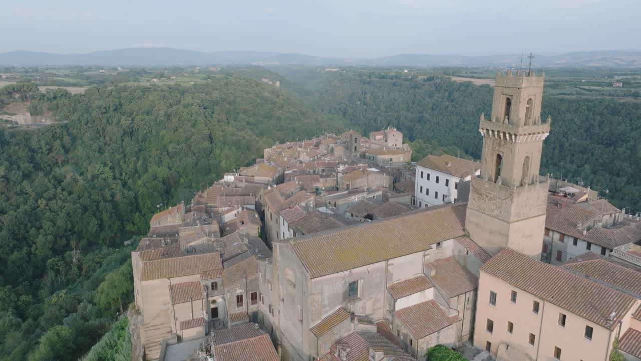 Aerial Drone view of the hilltop Medieval town of Pitigliano, Tuscany and the Valdorcia in morning light, flying over old buildings and rooftops, in 4K