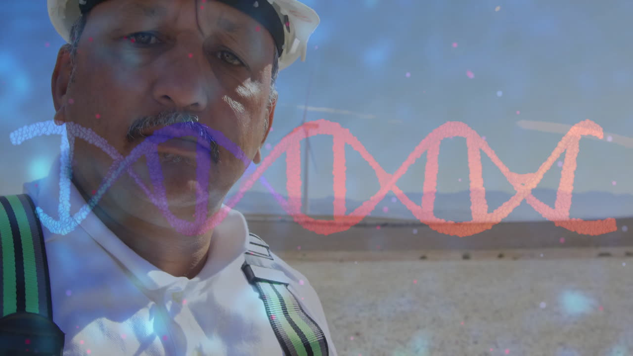 Man wearing protective suit and harness analyzing DNA helix graphic near wind turbine in tech