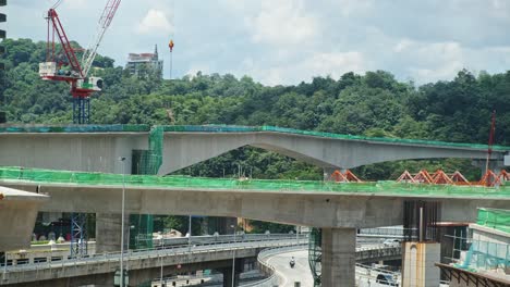 construction site of new bridge with crane over freeway intersection road circle in asia