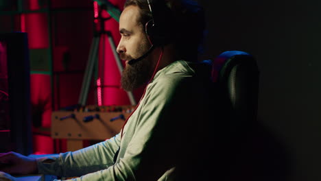 man chatting with teammates online while playing video games on gaming pc