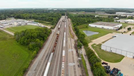 Vista-Aérea-De-4k-Que-Muestra-Varios-Trenes-Estacionados-En-Una-Estación-De-Tren-Esperando-Para-Salir