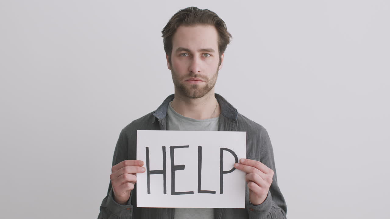 Man holding a sign that says help