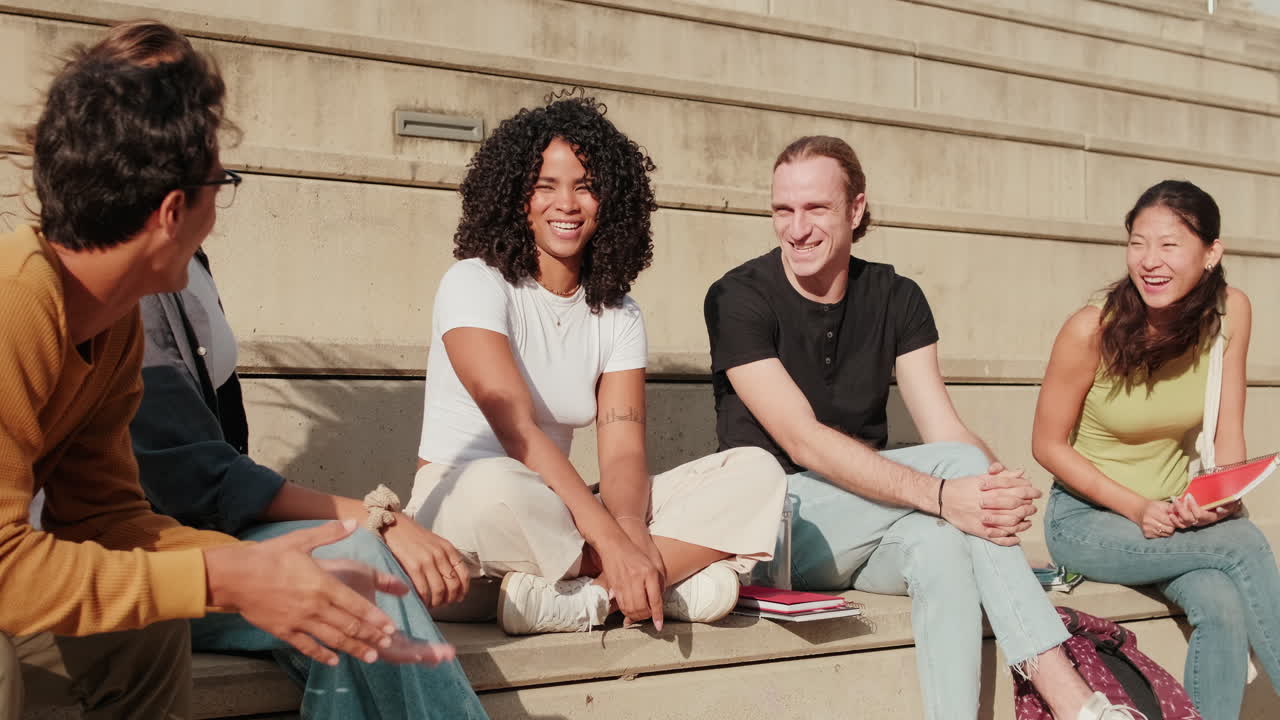 Close up side view of the group of happy students with study items is sitting