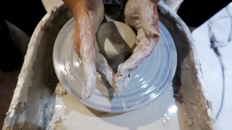 overhead close view of an african american hands spinning clay very sporadically