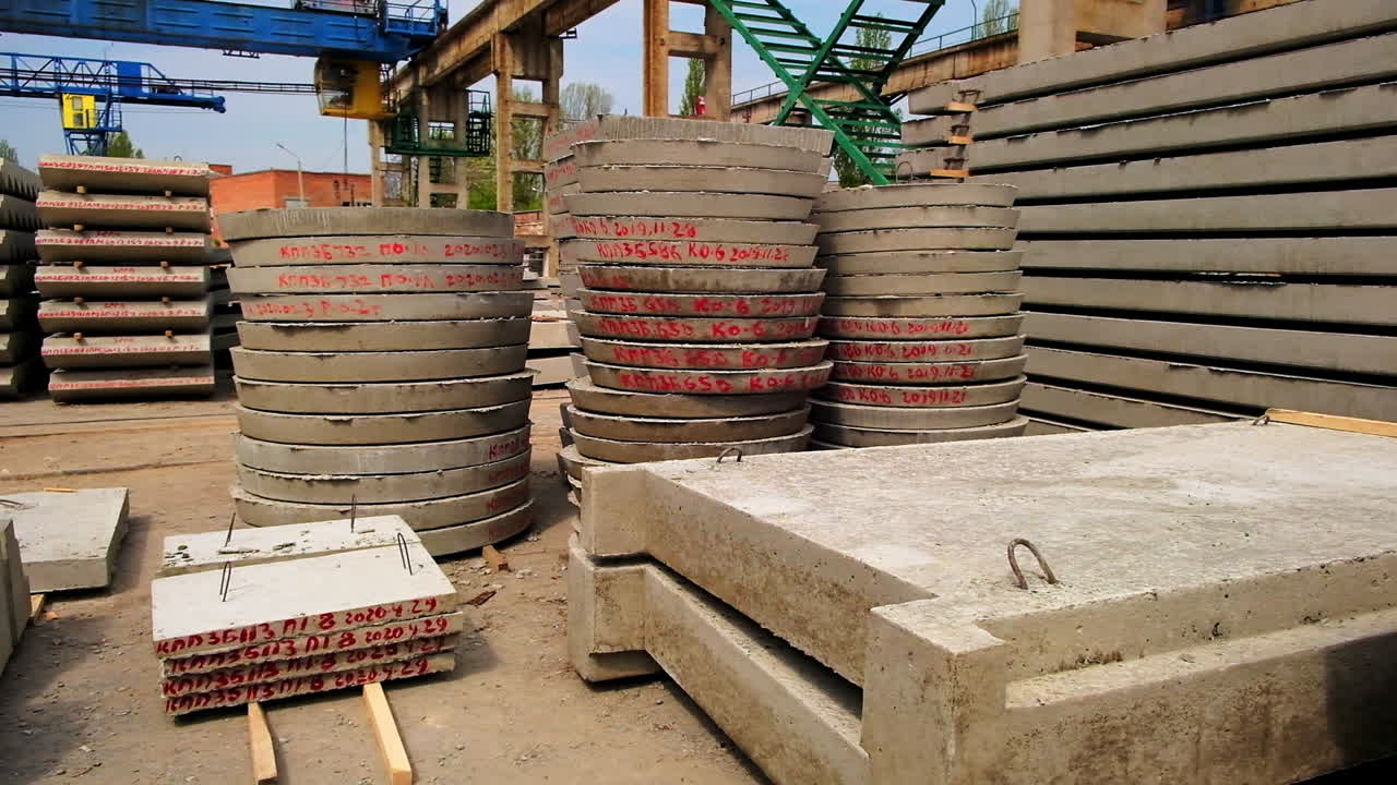 Cement grey building materials with red letters and numbers. Construction metal supports and mechanisms at the backdrop.