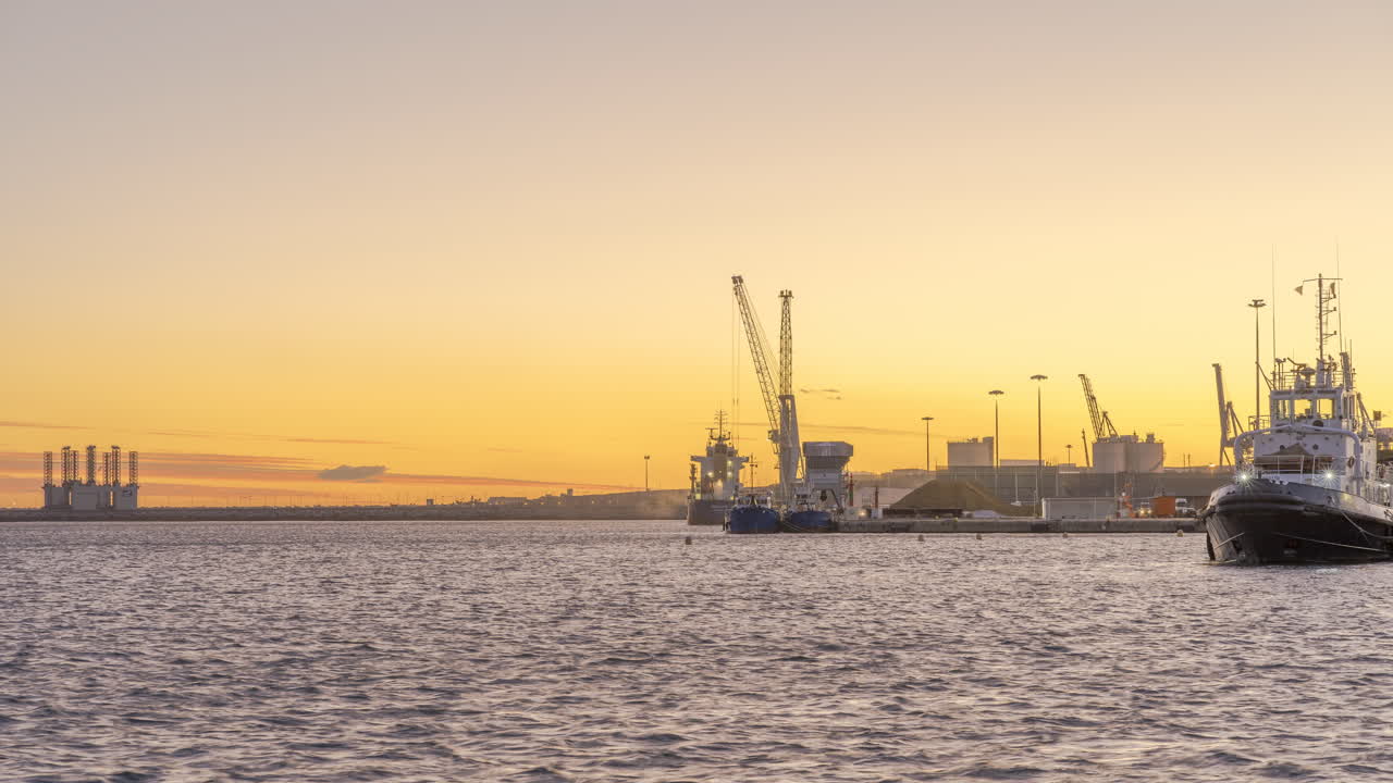 grúa industrial trabajando en el puerto cargando barco puesta de sol timelapse 4k