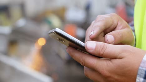 Male-worker-using-mobile-phone-in-the-junkyard-4k