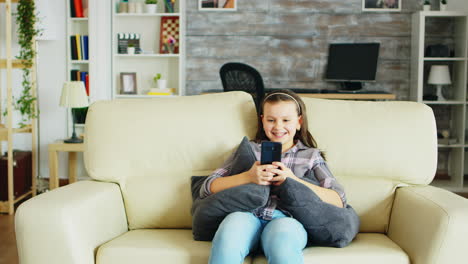 cheerful little girl with braces sitting on the couch