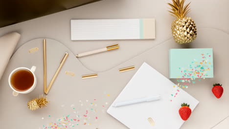 creative workspace flat lay with gold pineapple accents and strawberries