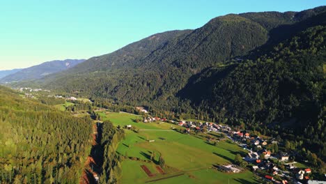 Pequeño-Municipio-En-Los-Alpes-Julianos-En-Un-Día-Soleado-Vibrante,-Vista-Aérea-De-Drones