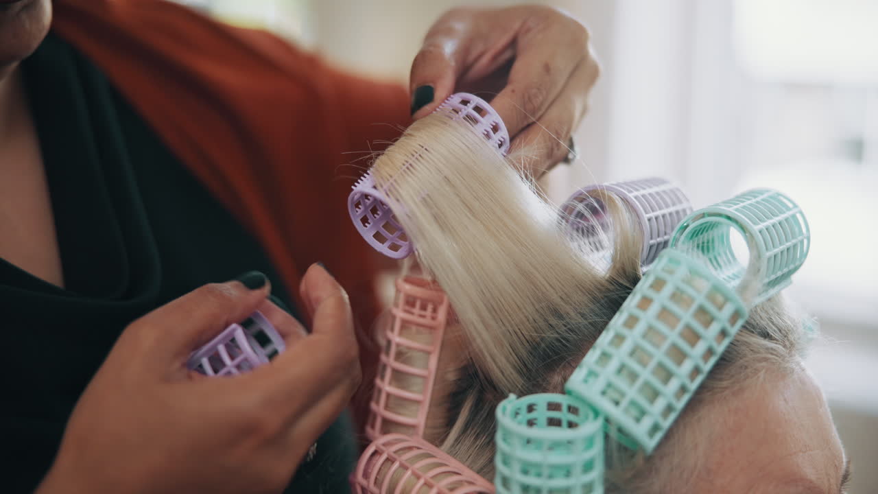 Close Up of Hairdresser Applying Curlers to Senior Woman's Blonde Hair