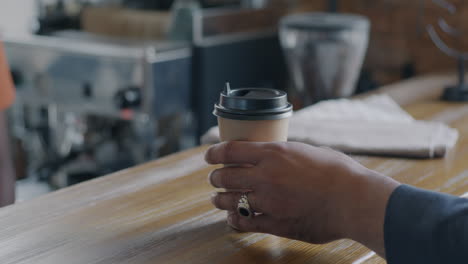 person holding coffee cup at a cafe