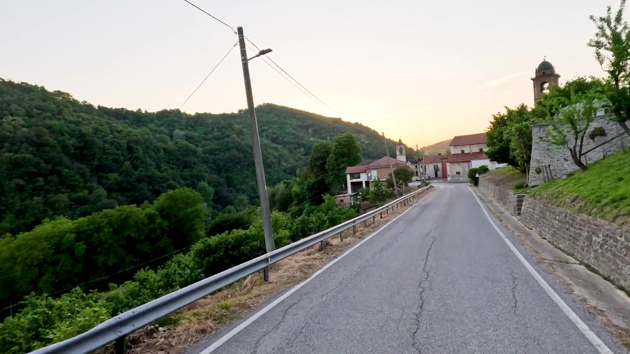 Una ripresa fluida in avanti segue una strada asfaltata tortuosa attraverso le pittoresche colline italiane.