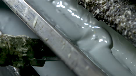 panning extreme closeup of bubbling light green-grey paint in an old and grungy wallpaper printer