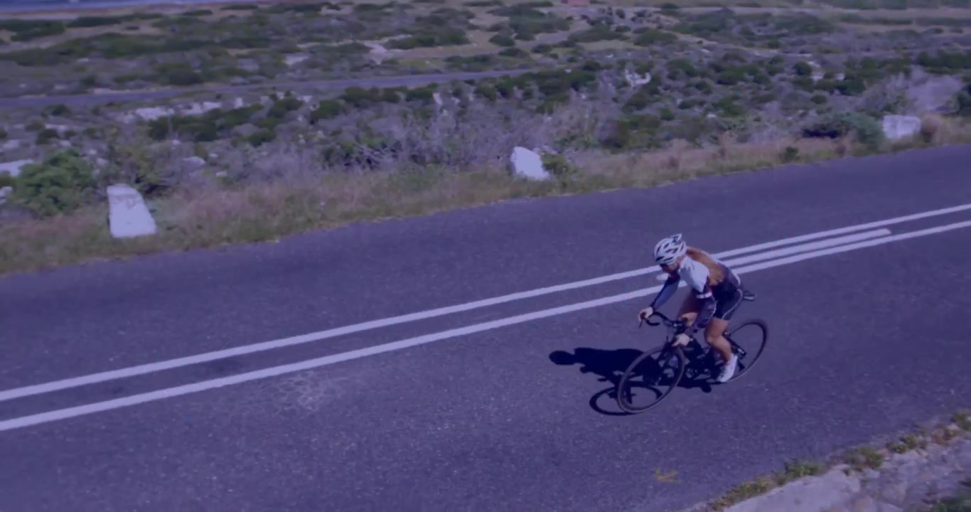 Sovrapposizione di mappa con icone di dati in sovrimpressione mentre una ciclista pedala in discesa per il monitoraggio delle prestazioni.
