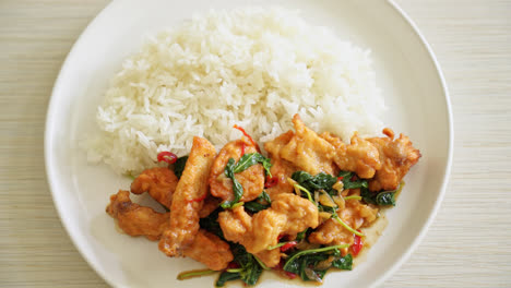 pescado frito salteado con albahaca y chile al estilo tailandés cubierto con arroz - estilo de comida asiática