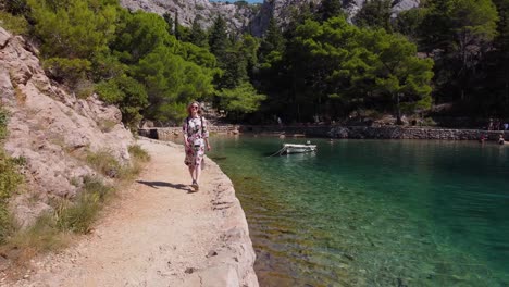 Blonde-girl-enjoying-a-walk-around-Zavrantica-Inlet,-scenic-attraction