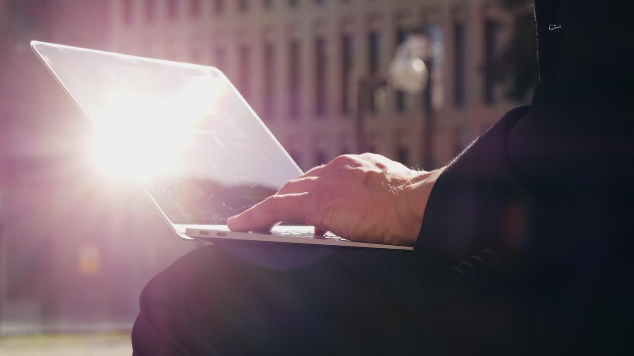 Asian businessman using laptop computer in the park, man working outdoor near modern office. Park street airport terminal