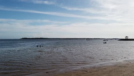 people swim at calm bali sea, sanur beach, skyline, pagoda gazebo travel spot in island of gods, blue horizon, indonesia, boats, southeast asia