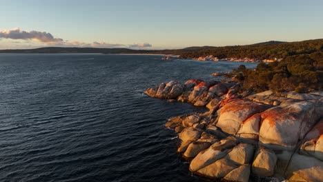 granite rocks along coast of bay of fires at sunset, tasmania in australia