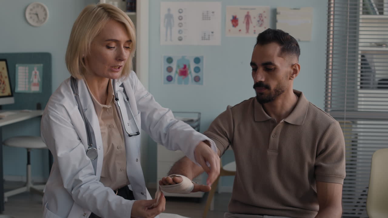 Doctor bandaging patient's hand
