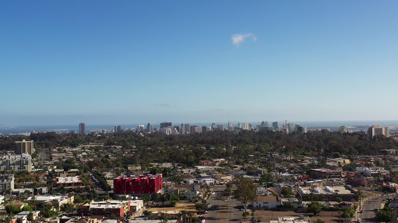 Dron letící směrem do centra San Diega z North Parku v 17:00, zachycující široký záběr panoramatu města a okolních čtvrtí.