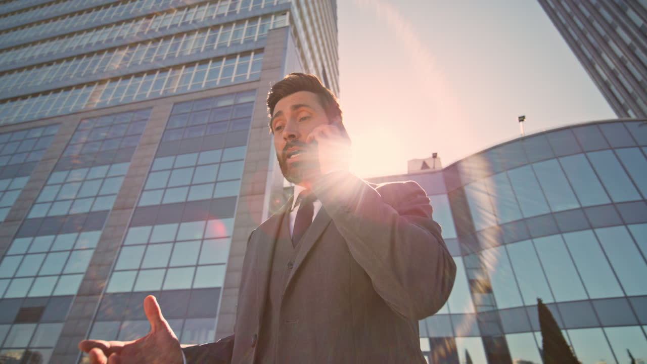 걱정스러운 매니저가 길거리의 빛에서 드폰으로 대화를 나누고 있습니다.