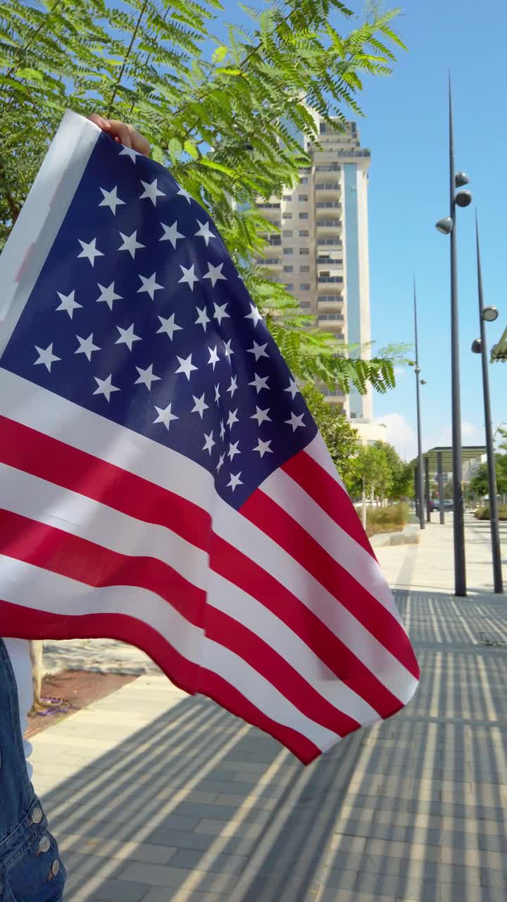 A person holding a red, white, and blue American flag