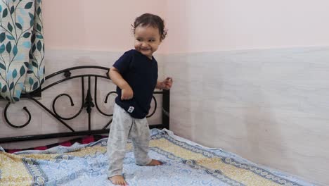 cute-toddler-baby-boy-trying-to-stand-for-the-first-time-at-bed-at-home
