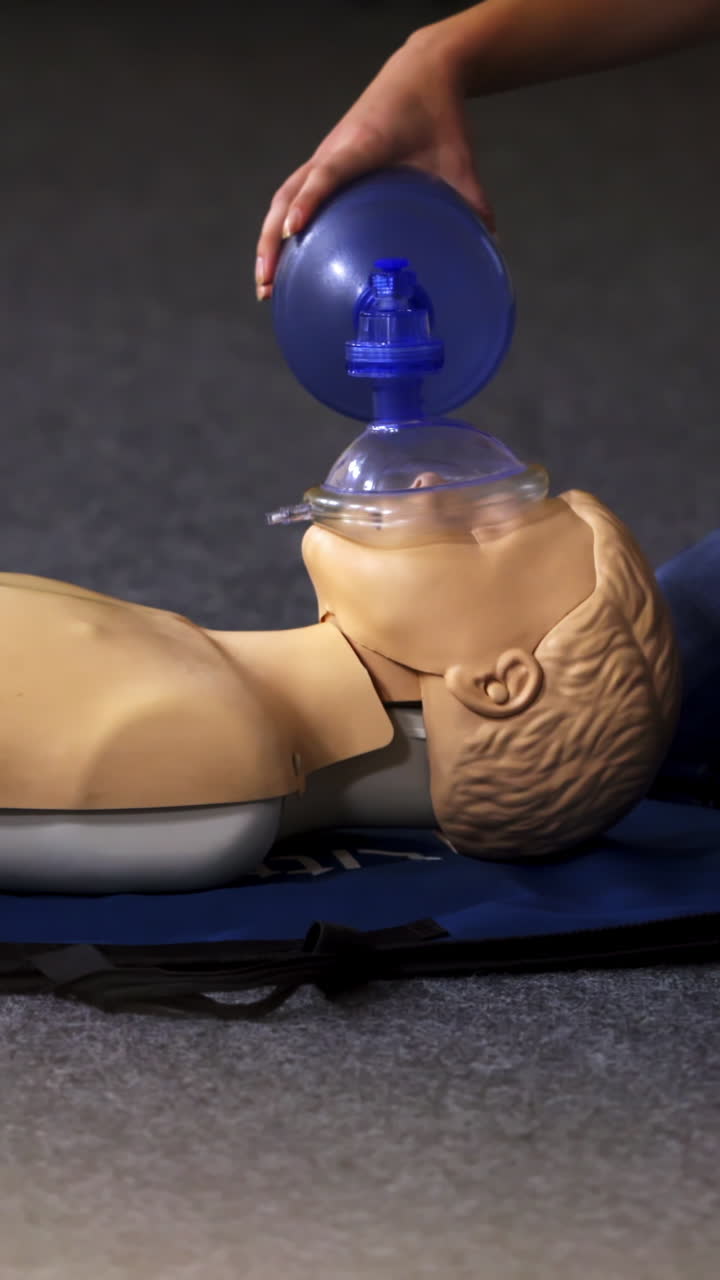 Medical doll lays on blue blanket ready for training. First medical help with oxigen masks video training. Vertical video